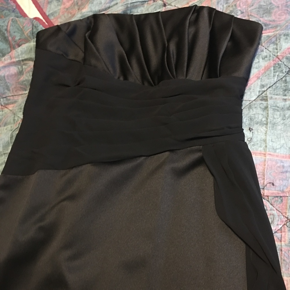 Sleeveless black gown with sash.
